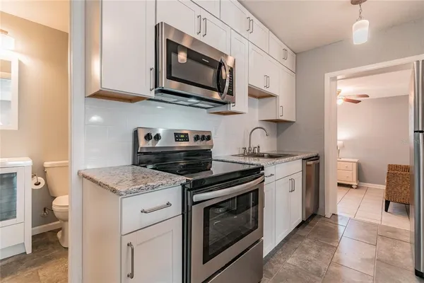 a kitchen with stainless steel appliances granite countertop a stove and a microwave