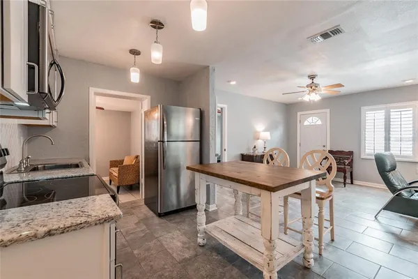 a kitchen with stainless steel appliances granite countertop a sink a stove and a refrigerator