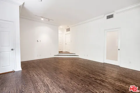 a view of an empty room with wooden floor