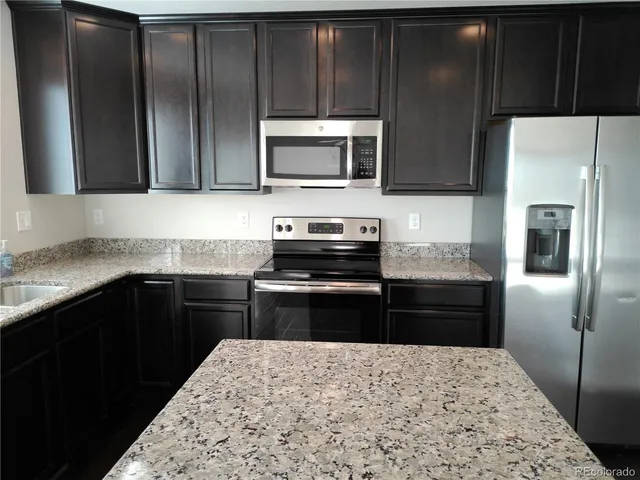 a kitchen with a refrigerator stove and microwave