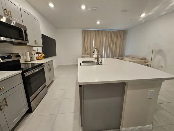 a kitchen with stainless steel appliances a sink dishwasher stove refrigerator and microwave
