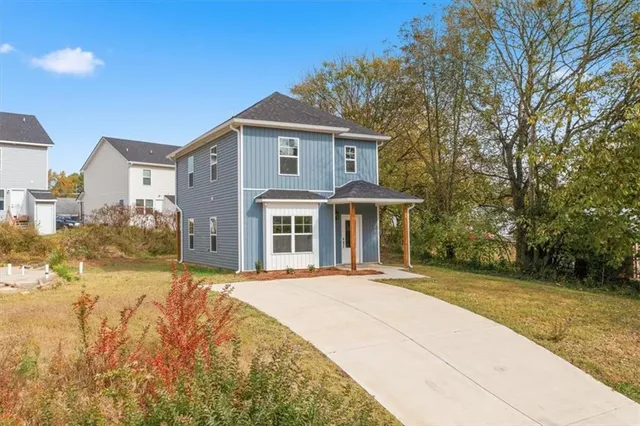 a front view of a house with a yard and potted plants