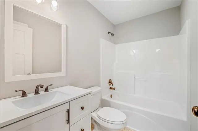 a bathroom with a bathtub shower sink vanity mirror and toilet