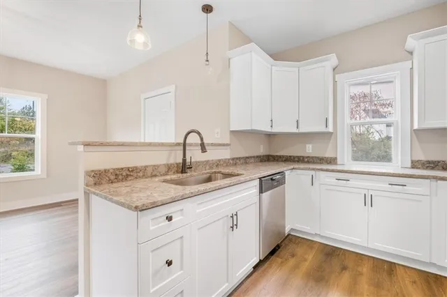 a kitchen with white cabinets appliances and a window