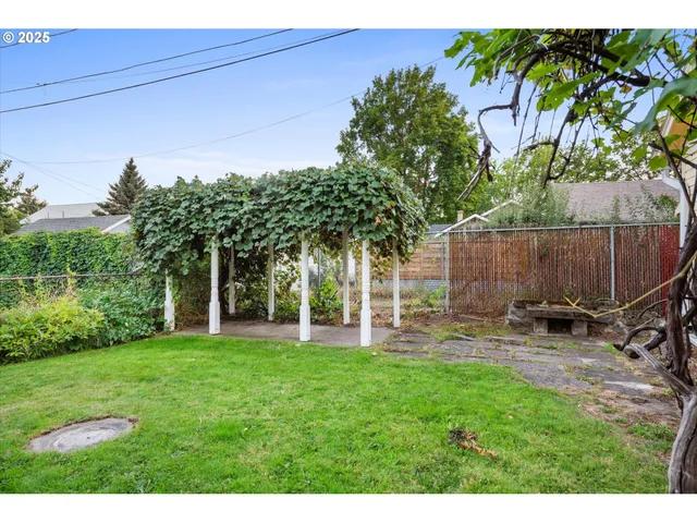 a view of a backyard with a garden and entertaining space
