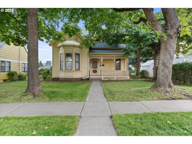 a front view of a house with a yard and an trees