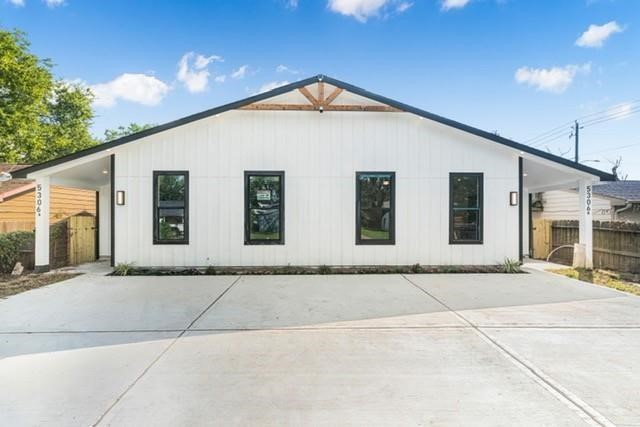 Modern duplex exterior featuring clean architectural lines, board-and-batten style detailing, covered entry, private driveway, and contemporary curb appeal.