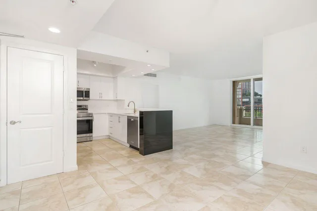 a view of kitchen with kitchen island cabinets and refrigerator