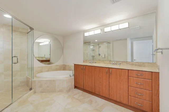 a bathroom with a bathtub shower sink and mirror