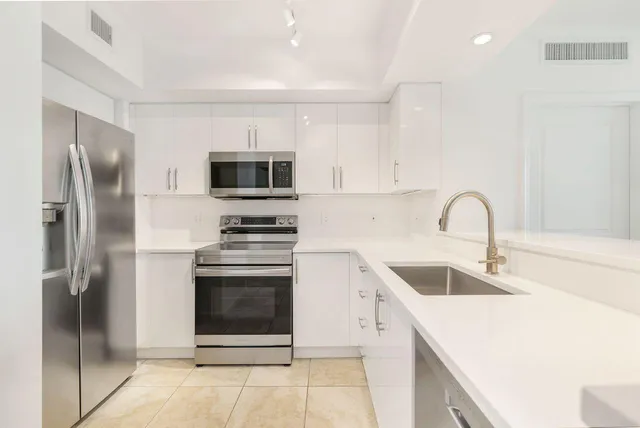 a kitchen with a sink cabinets and stainless steel appliances