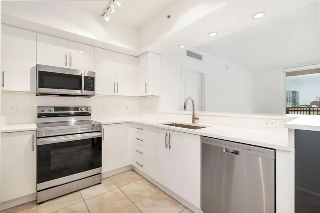 a kitchen with sink a microwave a stove and cabinets