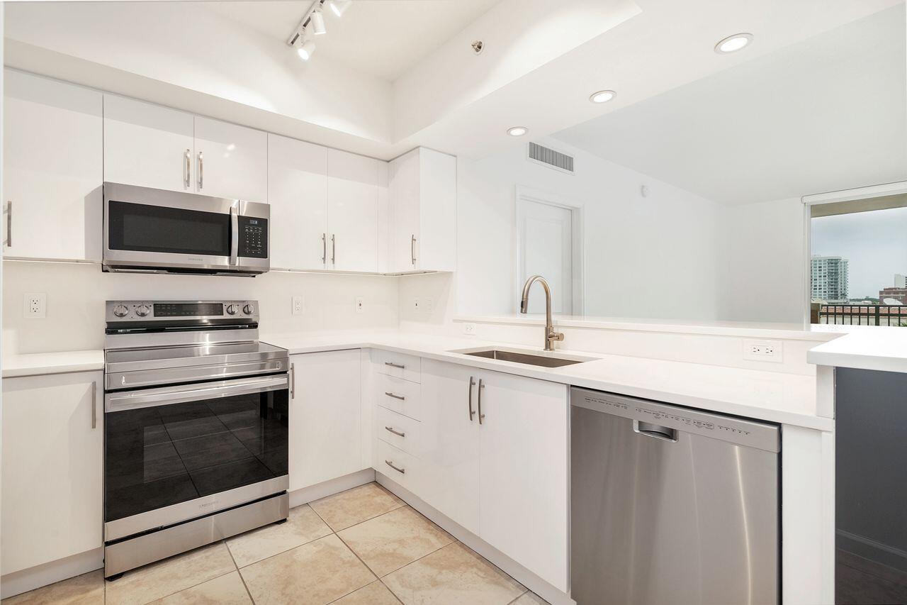 403 South Sapodilla Avenue, Unit 509 West Palm Beach, FL 33401 - Photo 9 of 42 a kitchen with sink a microwave a stove and cabinets