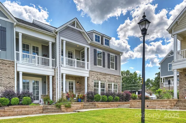a front view of a building with yard and swimming pool