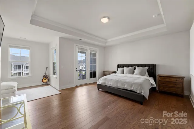 a spacious bedroom with a bed and wooden floor