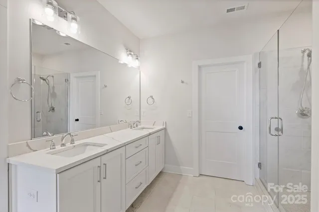a spacious bathroom with double sink a mirror a shower and a bathtub