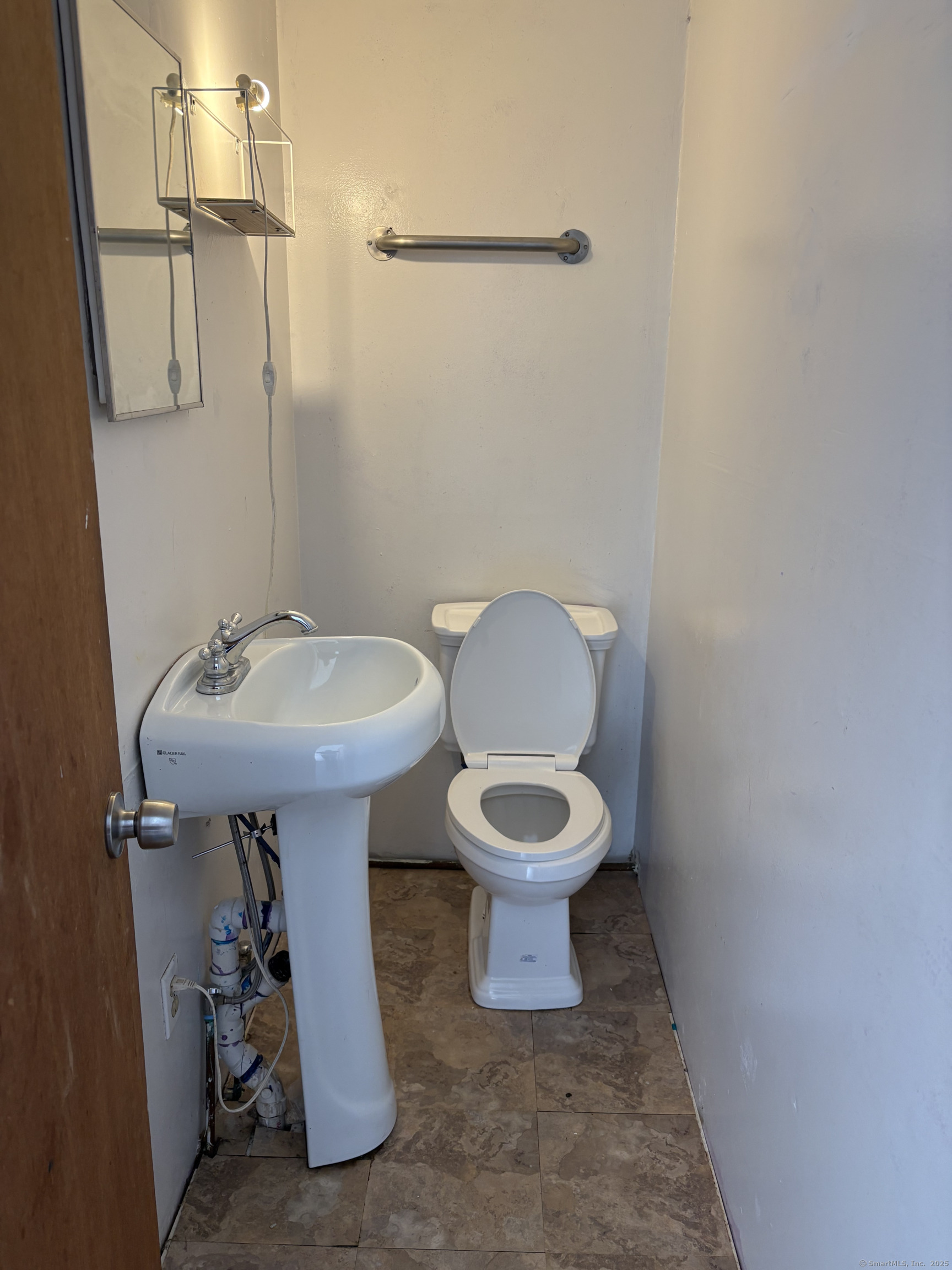 Undisclosed Address West Haven, CT 06516 - Photo 12 of 16 a white toilet sitting next to a bathroom sink