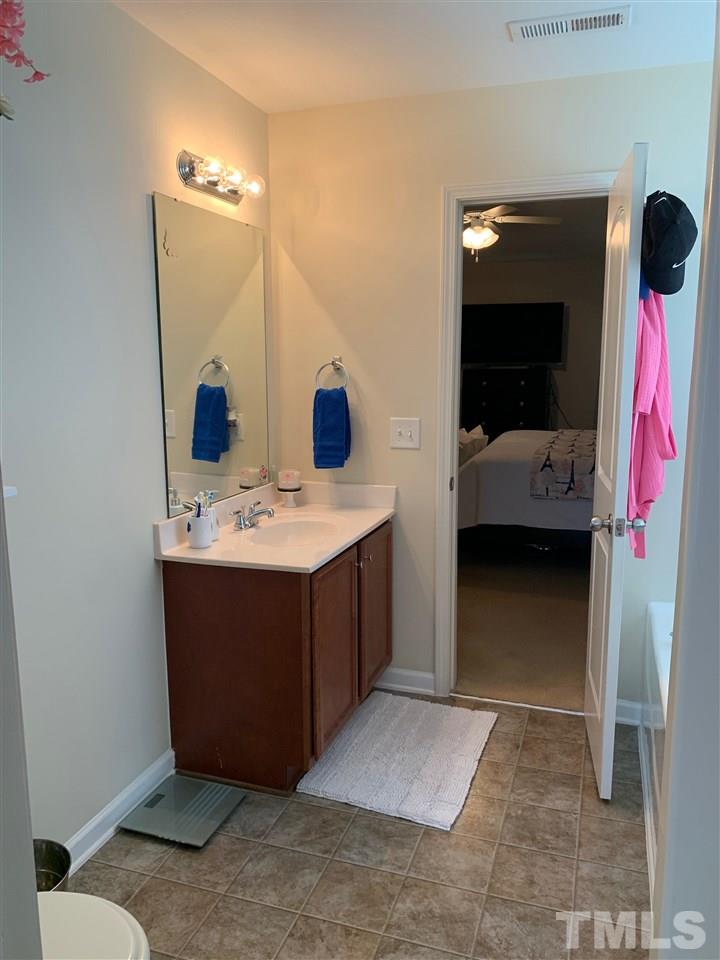 5701 Quitman Trail Raleigh, NC 27610 - Photo 22 of 28 a en suite bathroom with a sink and a mirror
