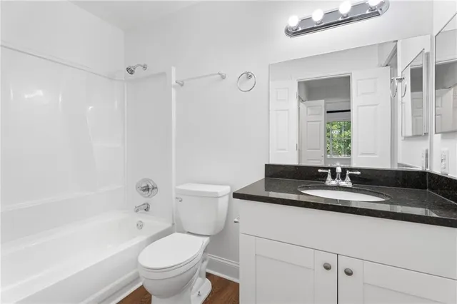 a bathroom with a granite countertop toilet a sink and a bathtub