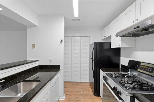 a kitchen with stainless steel appliances granite countertop a refrigerator and a stove