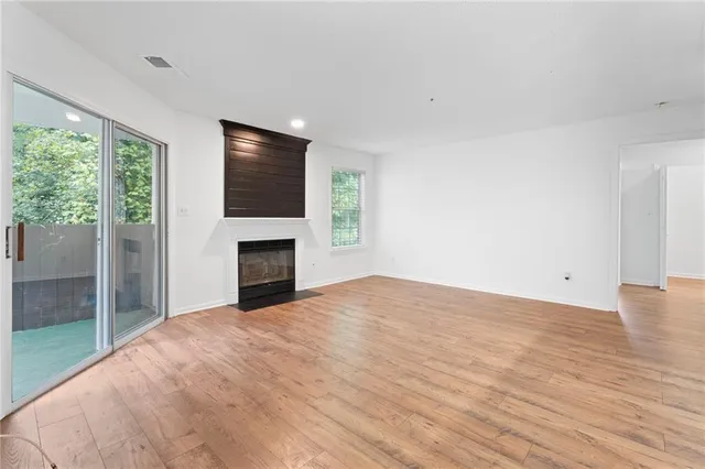 a view of empty room with wooden floor and fireplace