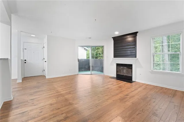 a view of empty room with wooden floor and fireplace
