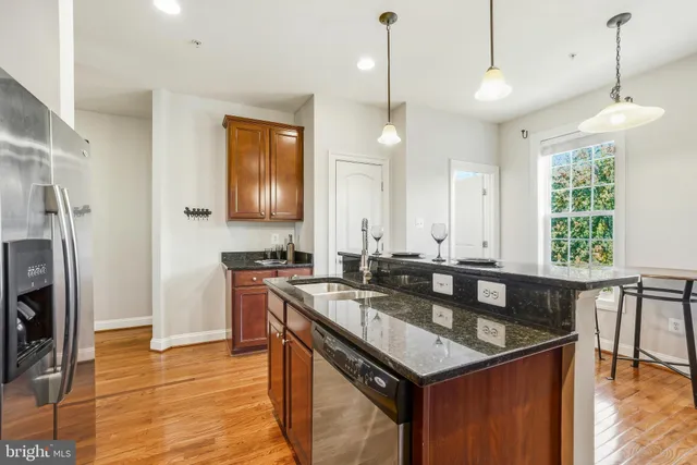 a kitchen with stainless steel appliances granite countertop a sink a stove and a refrigerator