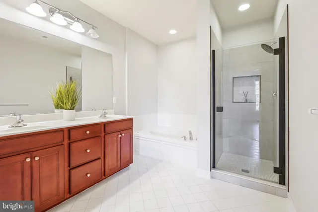 a bathroom with a tub a double vanity sink and mirror