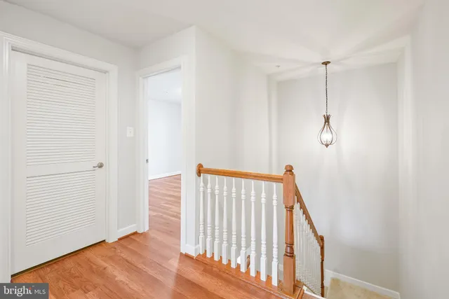 a view of a hallway with wooden floor and staircase