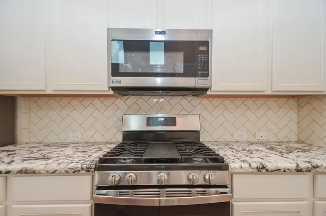 a stove top oven sitting inside of a kitchen