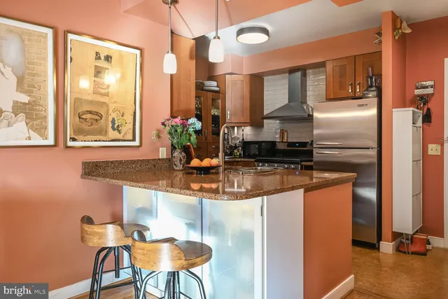 a kitchen with stainless steel appliances granite countertop a sink and a refrigerator