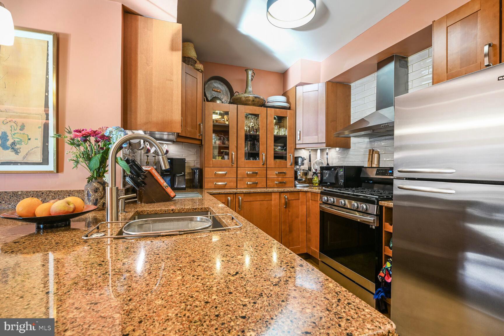 555 Massachusetts Avenue Northwest, Unit 901 Washington, DC 20001 - Photo 12 of 50 a view of a kitchen with stainless steel appliances and living room