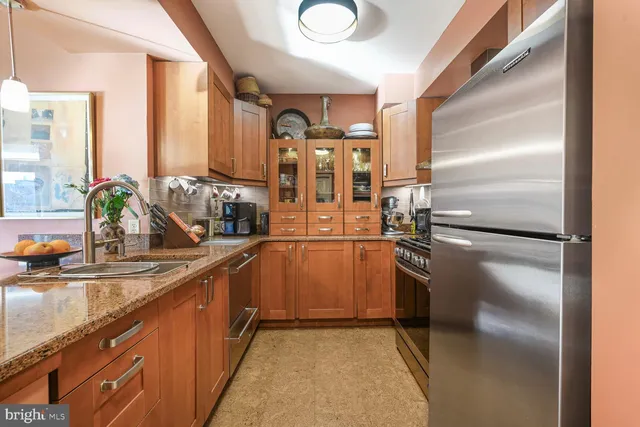 a kitchen with stainless steel appliances granite countertop a refrigerator and a sink