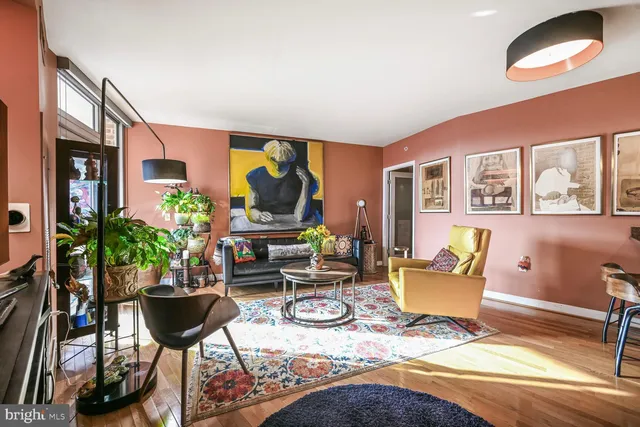 a living room with furniture fireplace and a large window