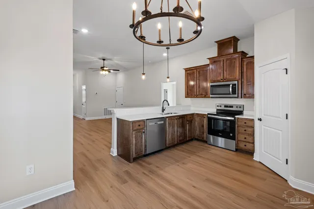 a kitchen with stainless steel appliances a refrigerator a stove a sink and a microwave