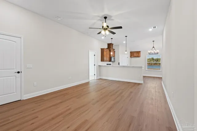 a view of a kitchen with wooden floor and a ceiling fan