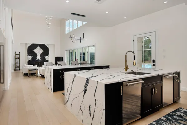 a kitchen with stainless steel appliances a sink a stove and a wooden floors