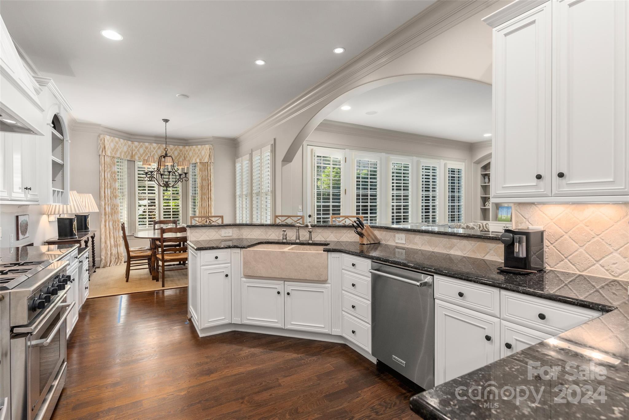 8432 Highgrove Street Charlotte, NC 28277 - Photo 12 of 46 a large white kitchen with a large window a sink and stainless steel appliances