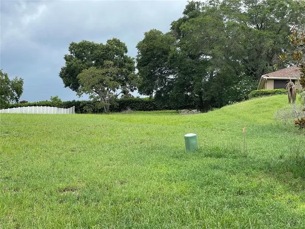 a view of a green field with wooden fence