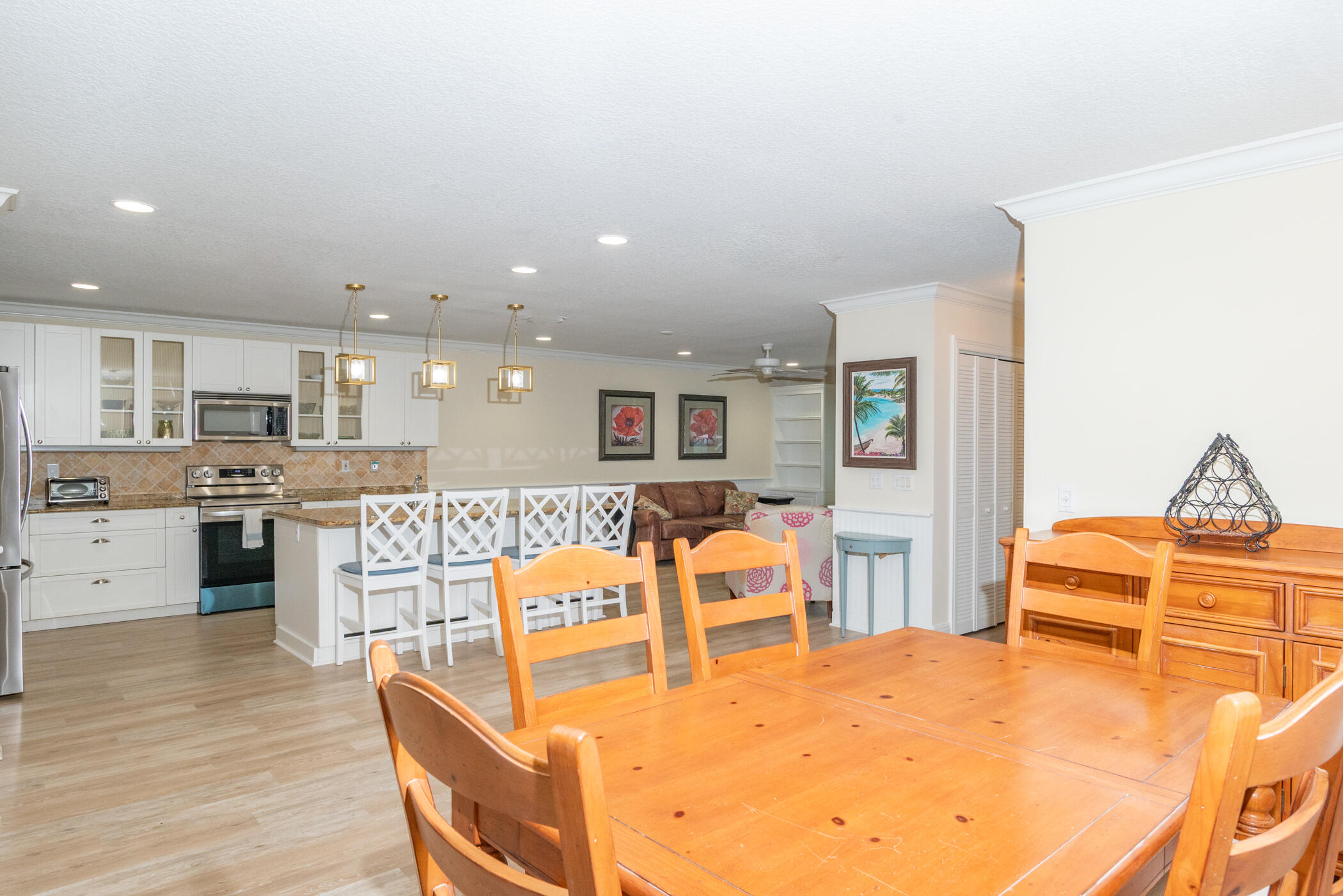 2918 Southeast Fairway West, Unit 13 Stuart, FL 34997 - Photo 10 of 34 a living room with stainless steel appliances kitchen island granite countertop a dining table chairs and view living room