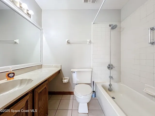 a bathroom with a granite countertop toilet sink and mirror