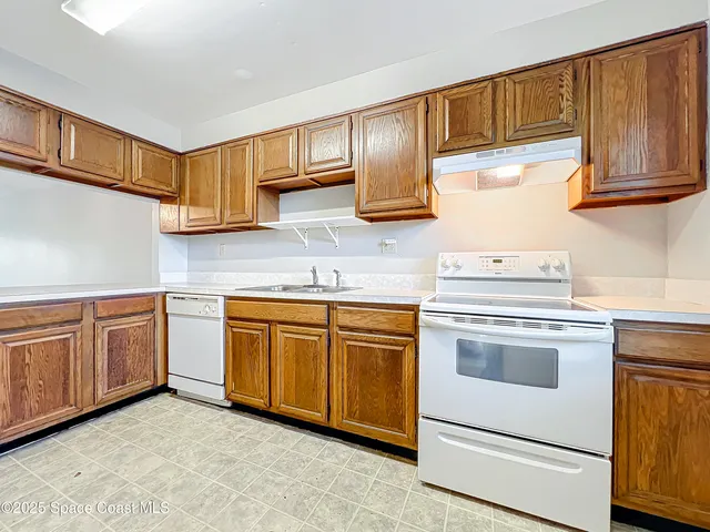 a kitchen with granite countertop cabinets stainless steel appliances and a sink