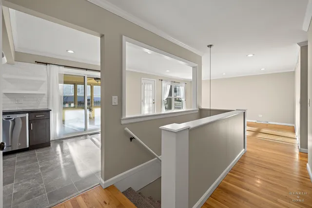 a view of a hallway with wooden floor and staircase