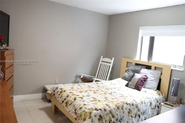 a large bed sitting in a bedroom next to a window