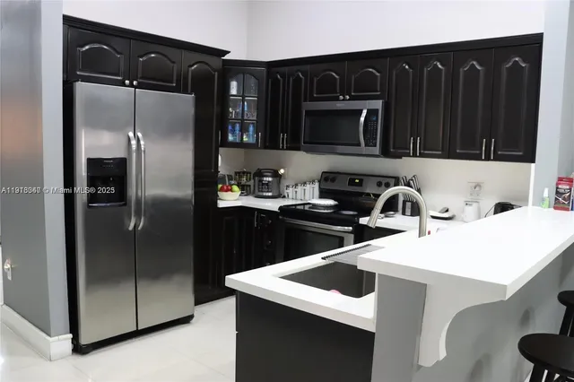 a kitchen with a sink a refrigerator and cabinets