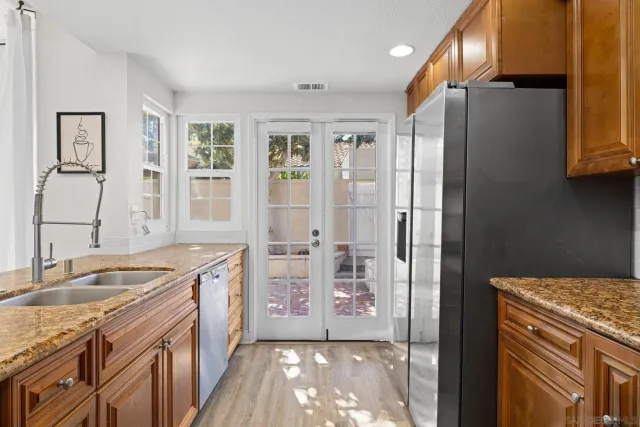 a kitchen with granite countertop a sink stove and refrigerator