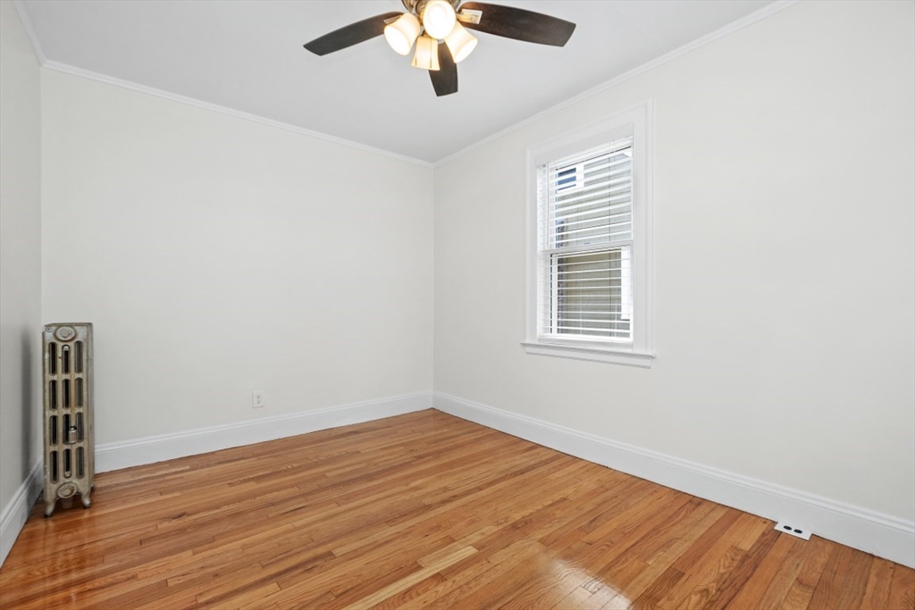 129 Virginia Road Waltham, MA 02453 - Photo 15 of 27 an empty room with wooden floor fan and windows