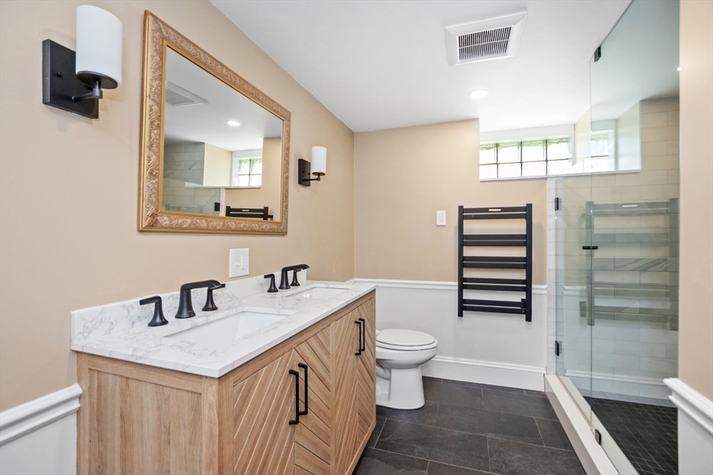 129 Virginia Road Waltham, MA 02453 - Photo 26 of 27 a bathroom with a sink a toilet and a mirror