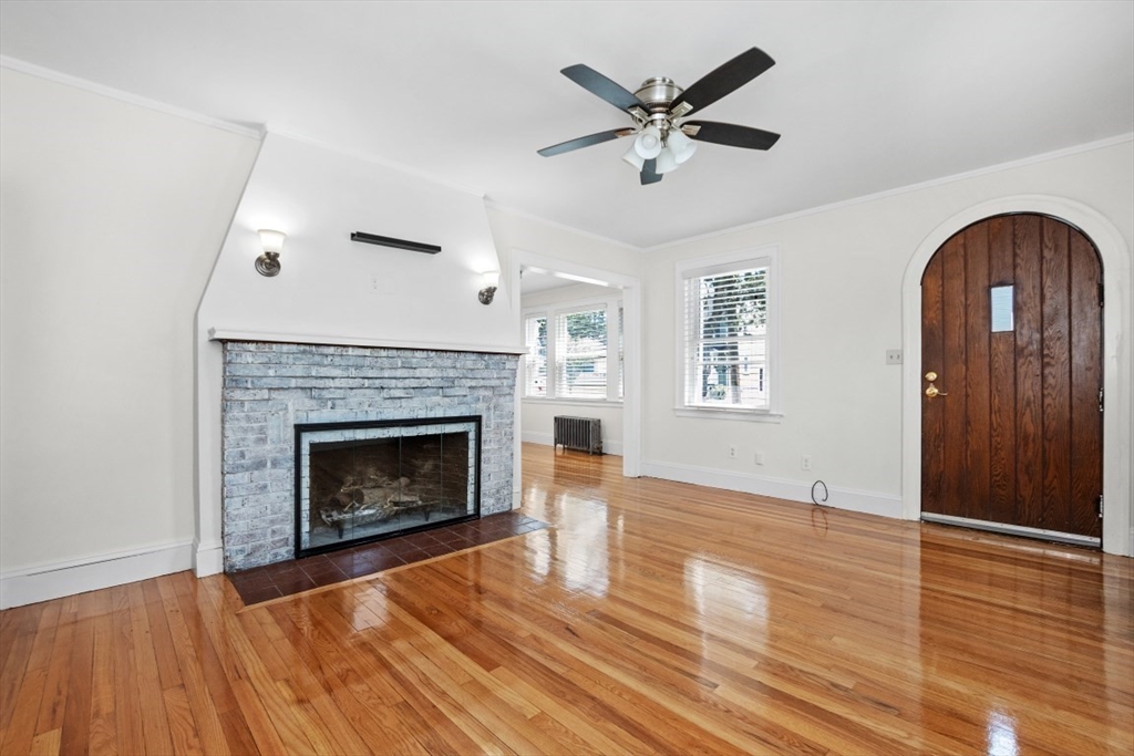 129 Virginia Road Waltham, MA 02453 - Photo 9 of 27 a view of an empty room with wooden floor and a fireplace