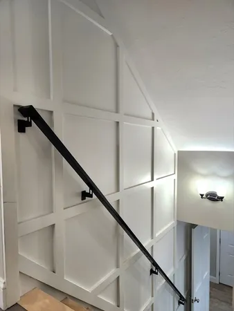 a view of staircase with white walls and railing