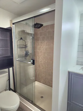 a bathroom with a shower a toilet and a sink